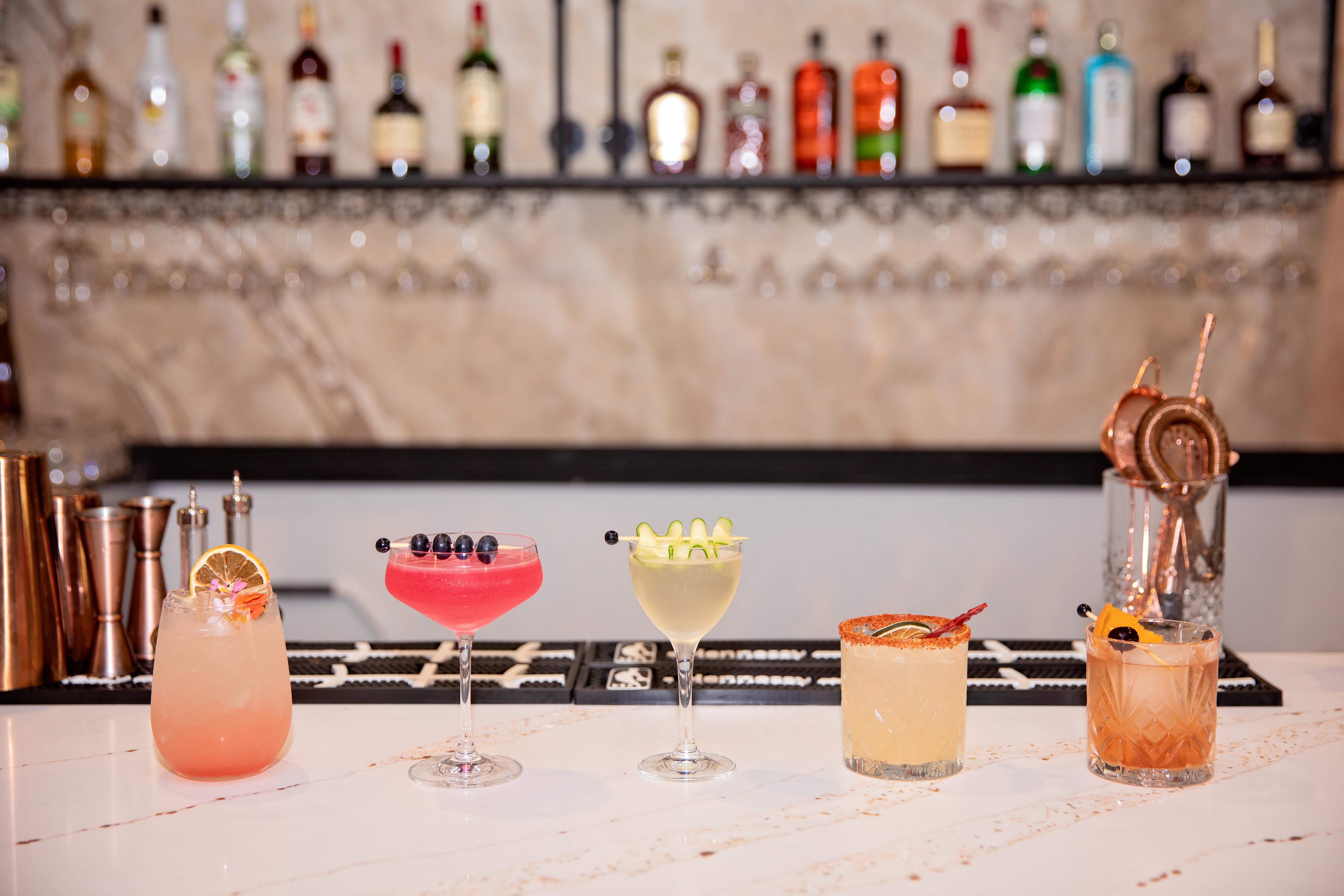 A five-cocktail flight lined up on the marble bar