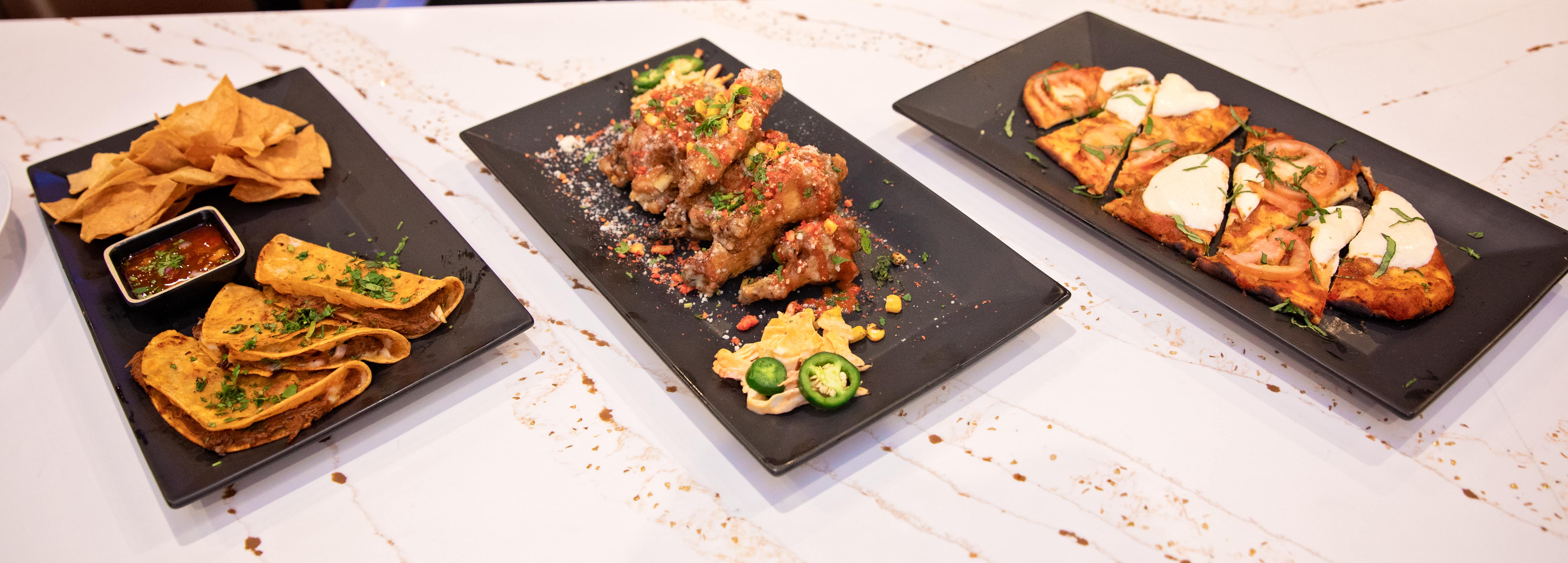 Shared appetizer spread with chips, wings, and flatbread