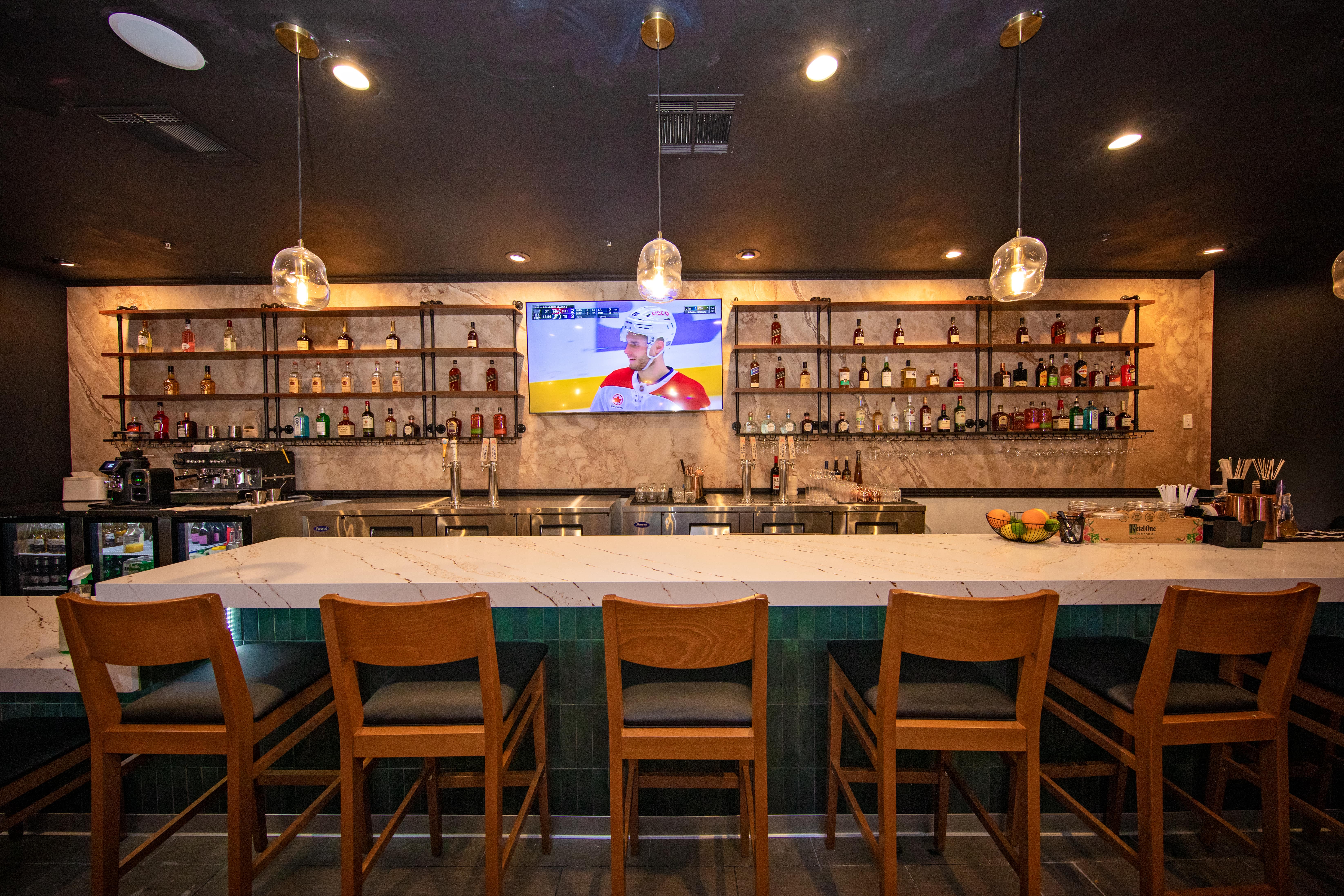 The bar back with full bottle shelving and a large sports TV