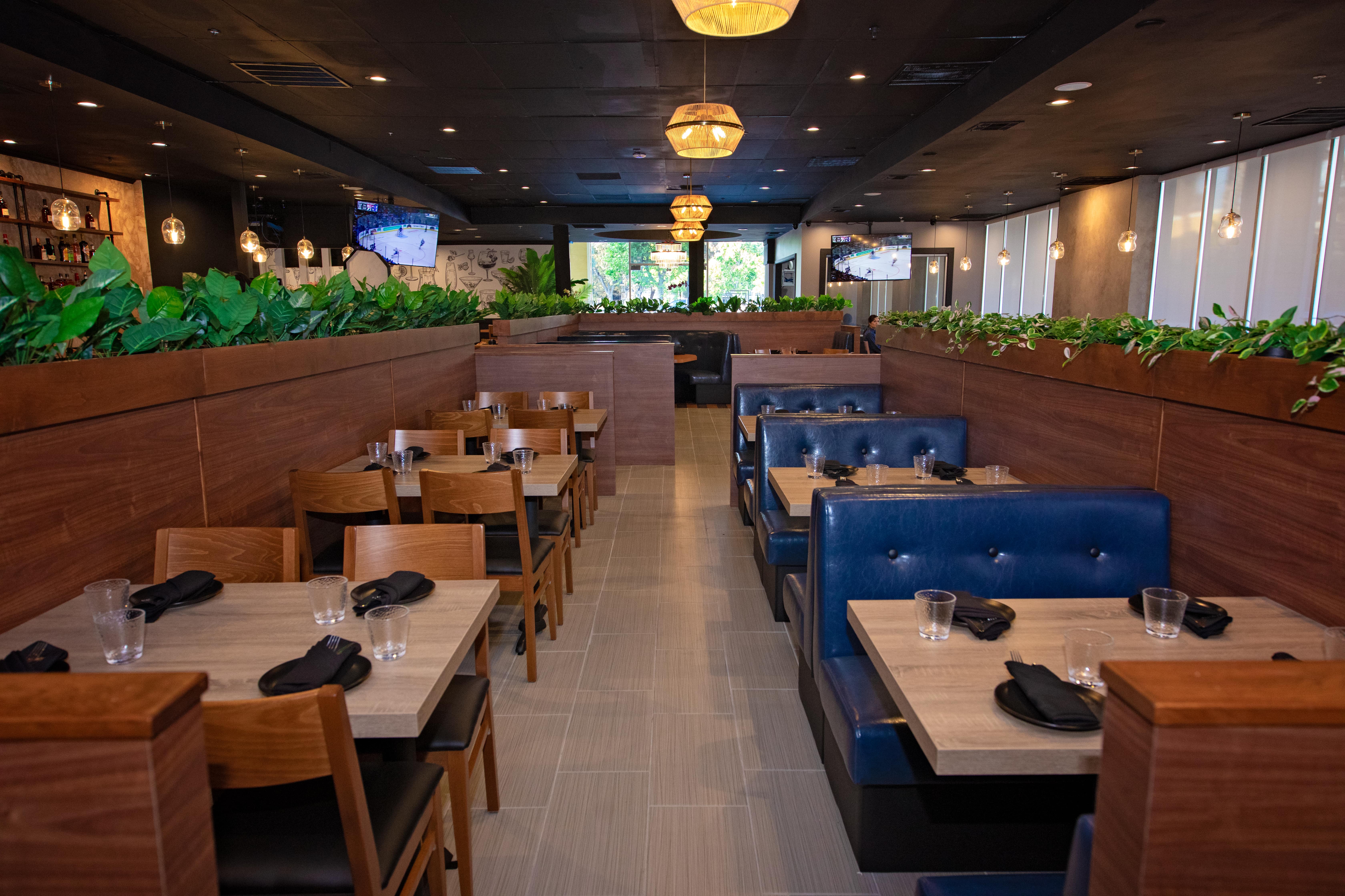 Toast & Tonique dining room with booths, wood tables, and pendant lighting