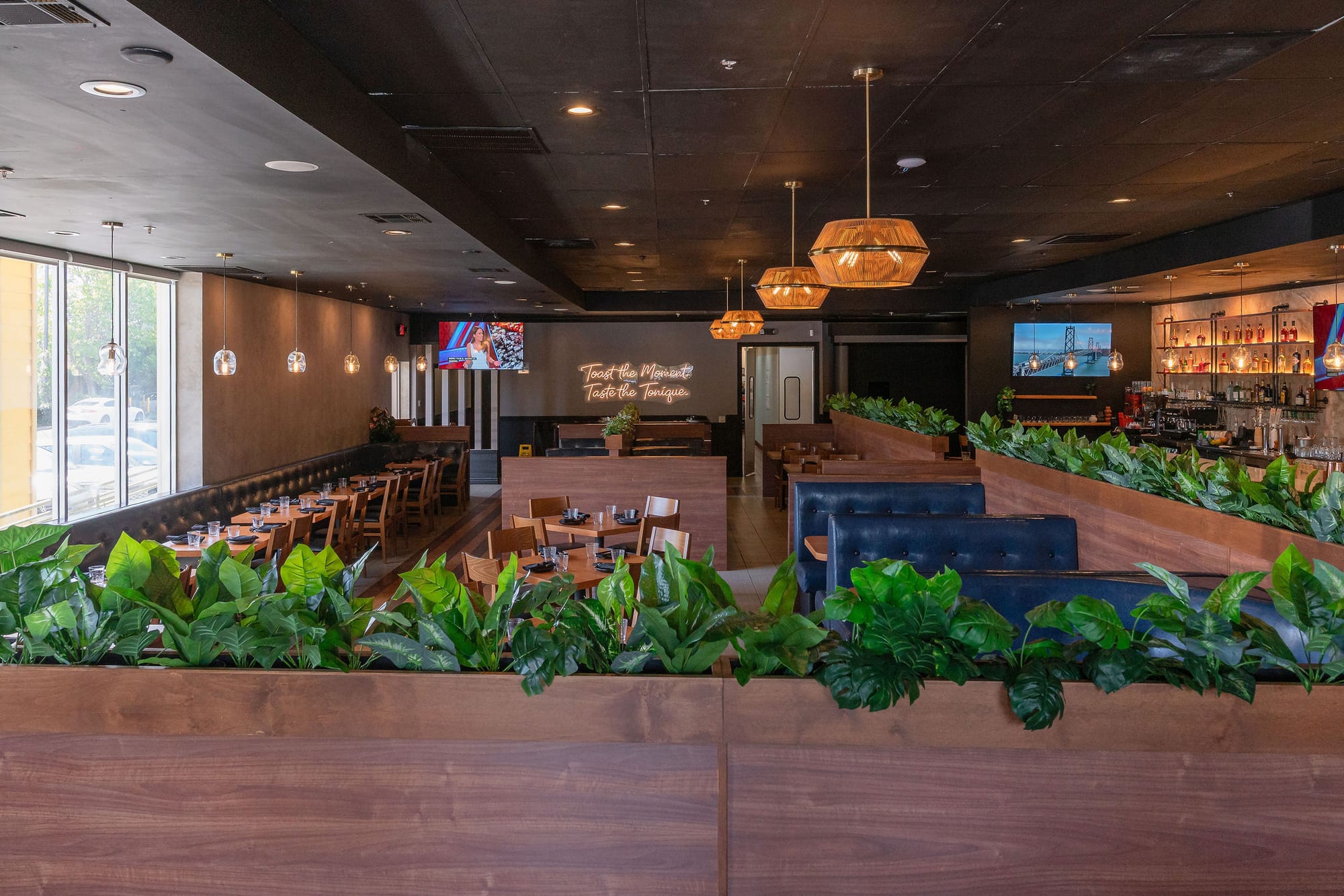 A long blue banquette lined with greenery dividers