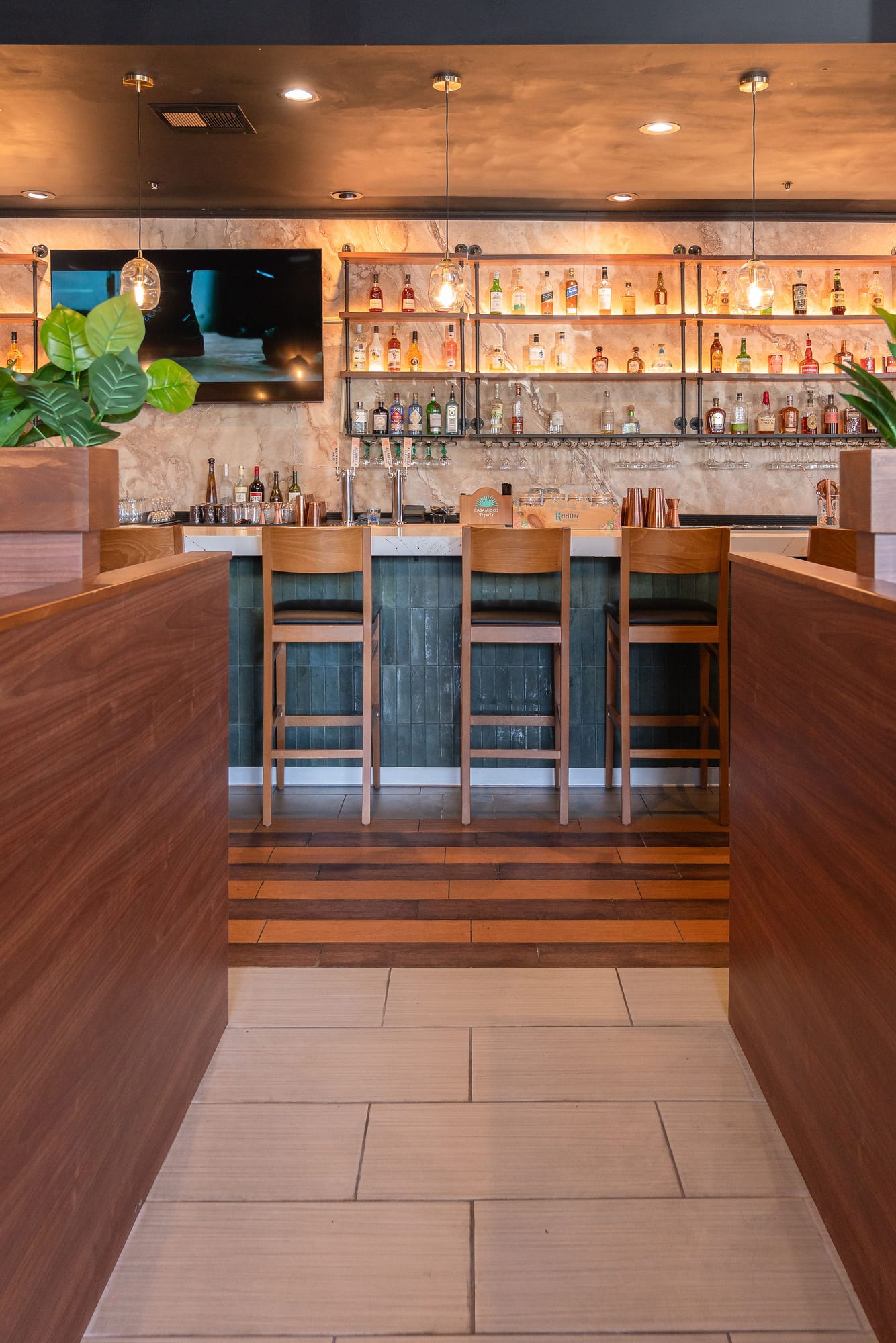 The marble-topped bar with a wood base beneath warm lighting